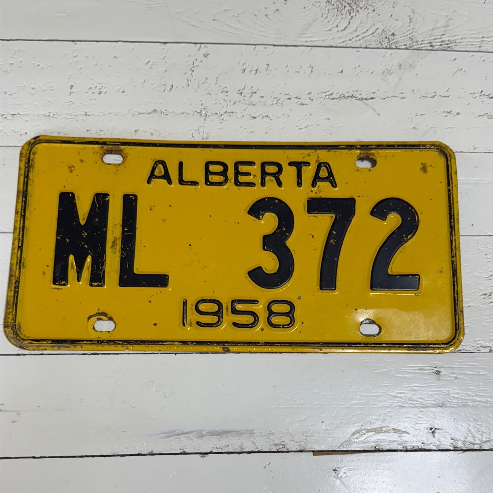 This is a vintage Alberta yellow and black license plate 1958